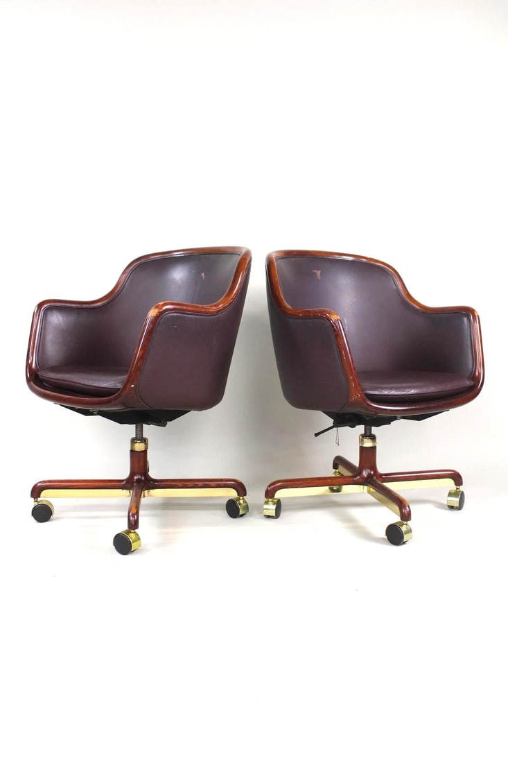 Pair of Ward Bennett Burgundy Leather & Brass Executive Chairs, Brickel, 1 of 2: Pair of Ward Bennett Leather Executive Office Chairs. These wood framed chairs have casters and nice burgundy plum colored leather. They are marked Ward Bennett. A tag underneath says covered in Knoll