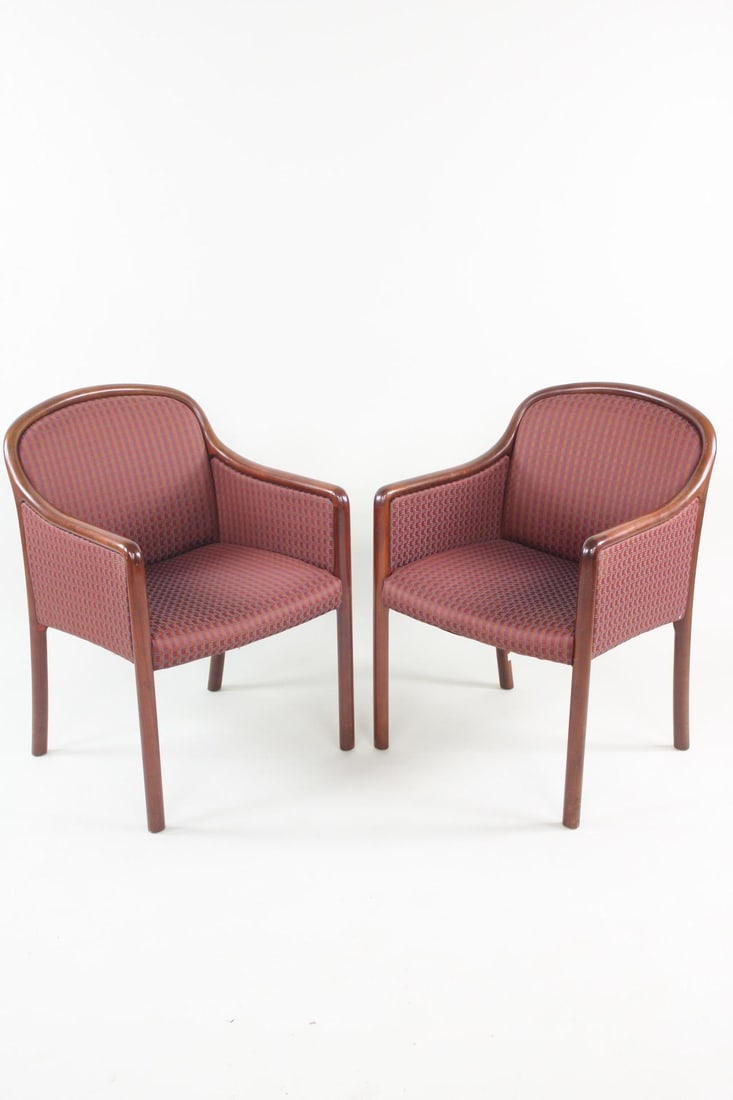Pair of Mid-Century Modern Upholstered Ward Bennett Style Armchairs: Pair of Mid-Century Modern Upholstered Ward Bennett Style Armchairs. These two executive chairs have rounded wooden frames with slightly angled backs, and a maroon, orange, and blue fabric upholstery.
