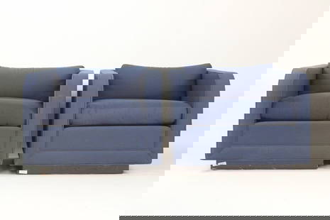 Pair of Upholstered Nicos Zographos Club Chairs: Pair of Upholstered Nicos Zographos Club Chairs. These cubist style armchairs have sloping front arms and a raised base, upholstered in a blue and red dotted fabric with matching seat cushions. Marked