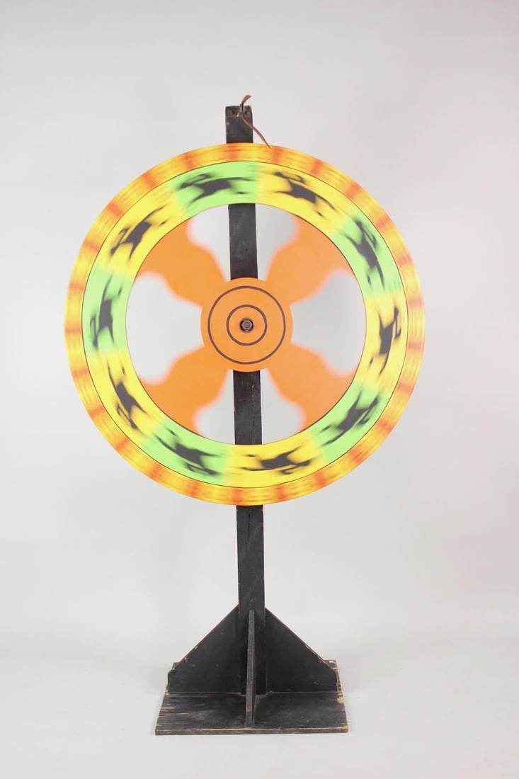 Large Carnival Horse Race Wooden Game Wheel on Stand: Carnival Horse Race Wooden Game Wheel on Stand. Brightly painted massive wooden game wheel, with leather ticker and nails serving as pegs. Removable from wooden stand. Dimensions are 81.5 in h x 48 in