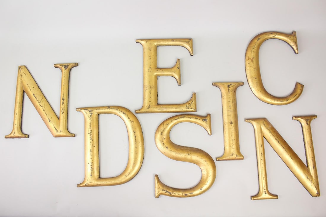 Collection of 7 Gold Gilt Wood Sign Letters: Collection of 7 Gold Gilt Wood Sign Letters. Letters are made of wood, finished in gold. Includes the capital letters D, E, N, C, S, I & N. Dimensions are 12 in h x 4.75 to 9.5 in w x .75 in d. Condit