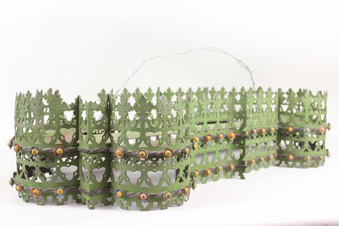 Perforated Steel Hanging Light Fixture Frame: Perforated Steel Hanging Light Fixture Frame. This metal piece has a dog bone shape and decorative open grillwork siding, with holes in place for hanging hardware and light bulbs. Painted green, yello