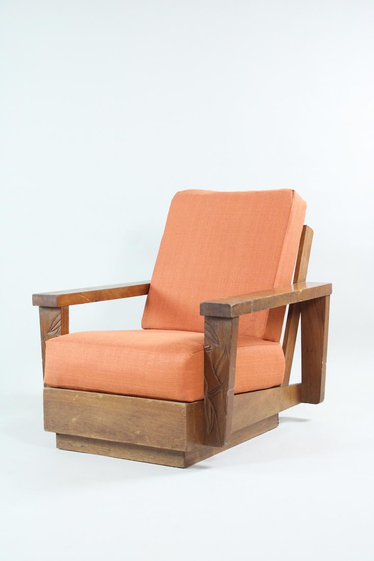 Mid-Century Hawaiian Carved Wood Lounge Chair: Mid-Century Hawaiian Carved Wood Lounge Chair. This wooden armchair has orange upholstered cushions and an angled reclined frame with open sides, plus hand carved leaf patterns on the front faces of t