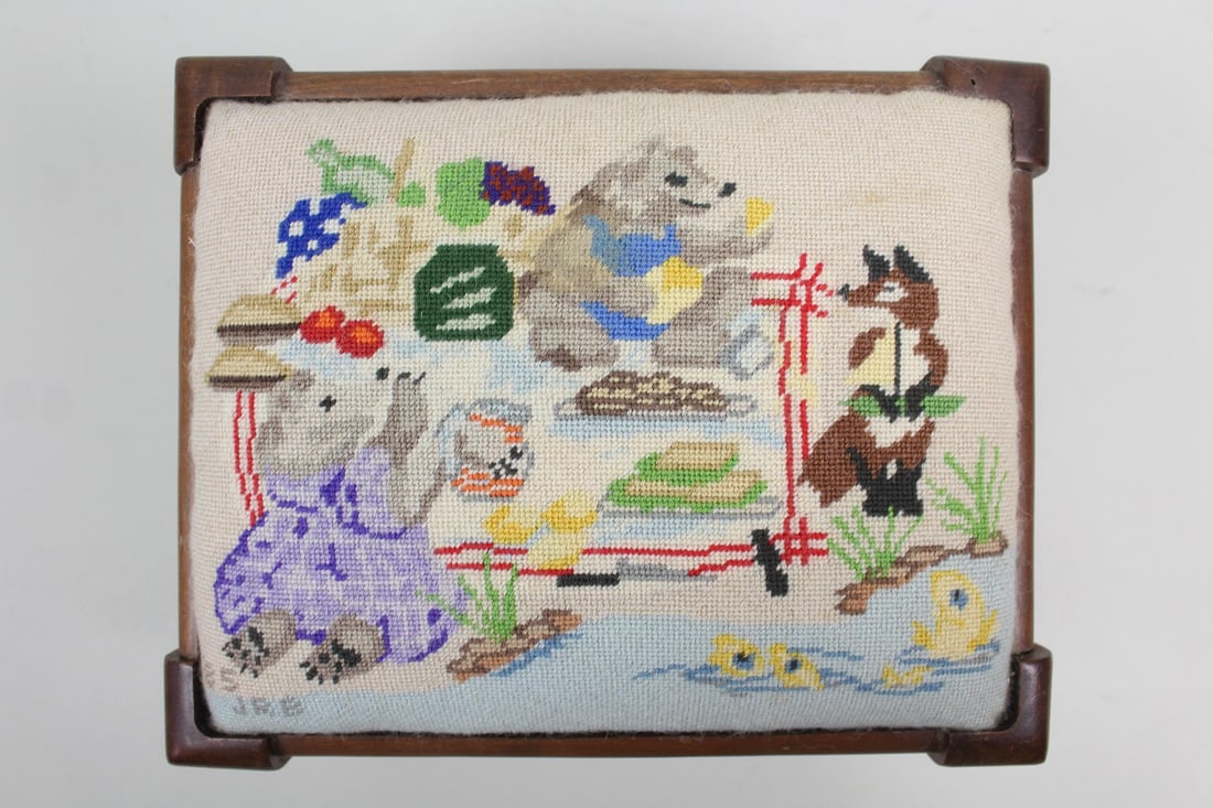 Needlepoint Foot Stool Animals Playing, Gudberry House: Needlepoint Foot Stool Animals Playing, Gudberry House. This wooden foot stool has Anthropomorphic Animals playing around on it. The bottom markedGudberry House. Dimensions are 8.25 in h x 11.25 in w