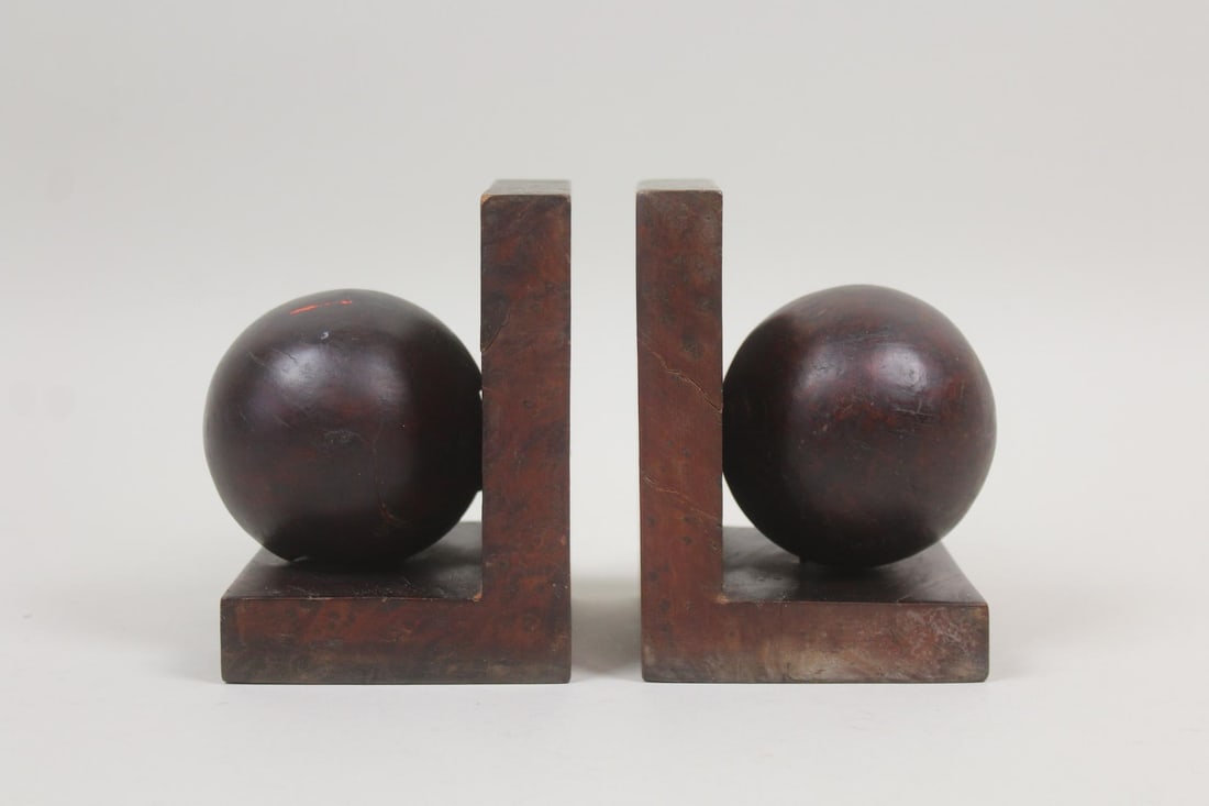 Pair of Burl Orb Bookends: Pair of Art Deco Burl Orb Bookends. Burl wood, possibly thuja root, spheres set on L-shaped burl wood holders. Dimensions are 5.5 in h x 4.25 in w x 4.25in d. Condition is good with minor wear to edge