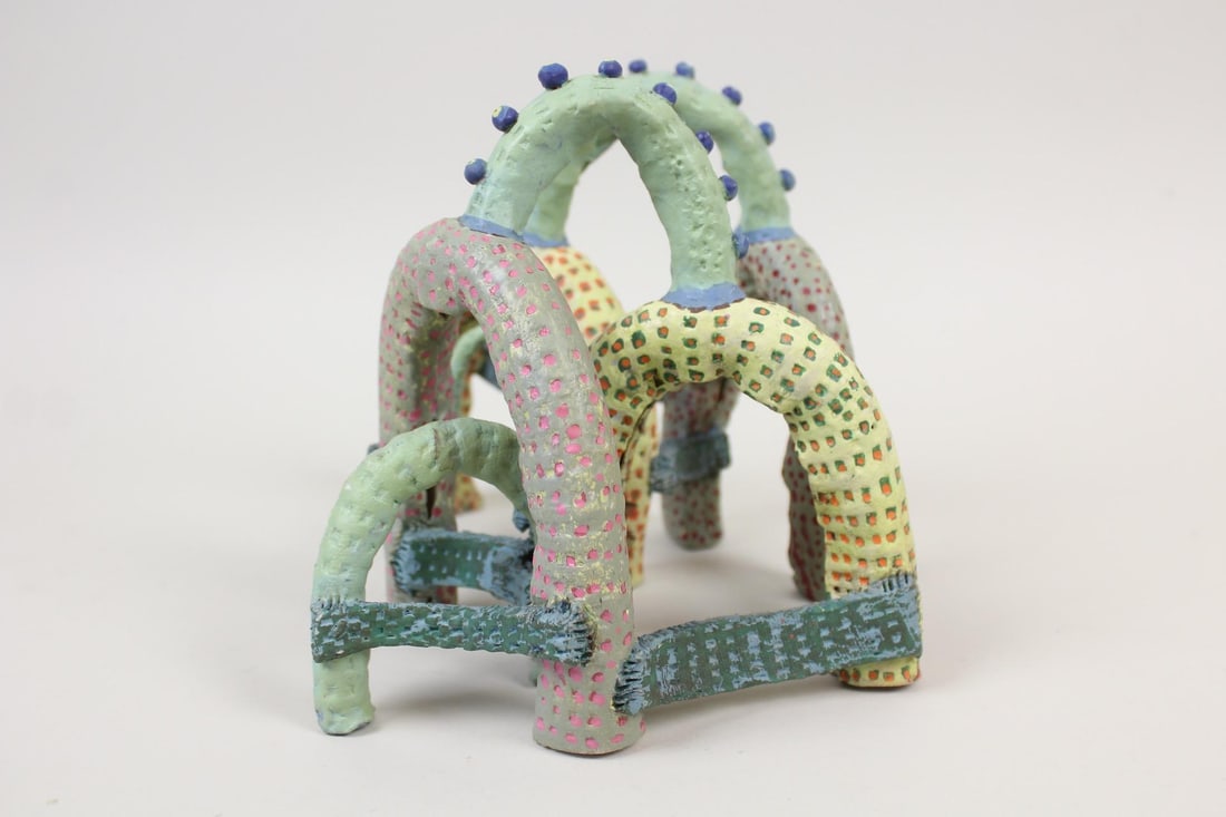 Abstract Clay Sculpture, Rainbow Jungle Gym: Abstract Clay Sculpture, Rainbow Jungle Gym. This handmade piece painted in multiple colors and dotted repeating patterns, is constructed from half-loop curved tubular pieces connected with bands pain