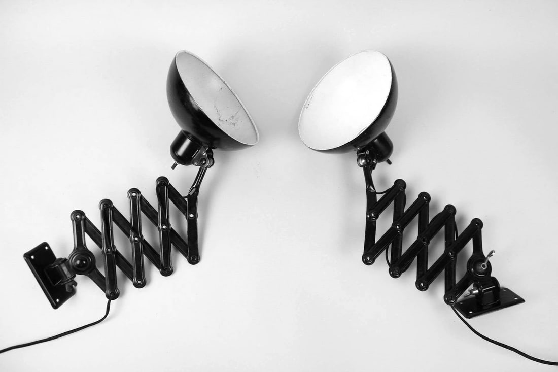 Pair of Scissor Wall Lamps, Christian Dell for Kaiser-Idell: Pair of Industrial Scissor Wall Lamps, Christian Dell for Kaiser-Idell. These metal wall mounted extendable lights have accordion bodies that adjust for length, and rounded cone shades, painted black.