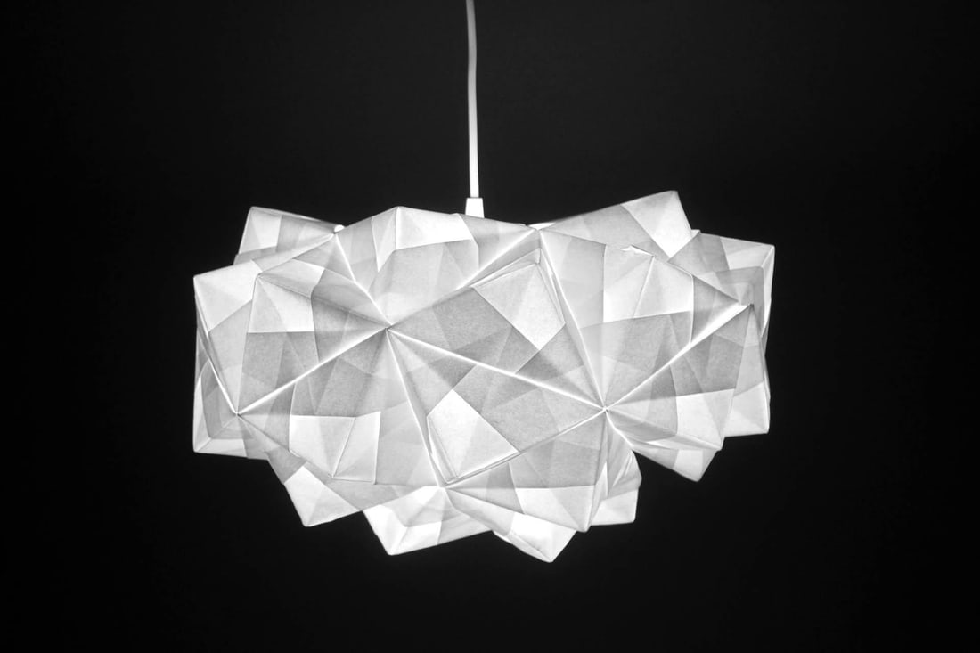 Foldability Petra Origami Pendant Light: Foldability Petra Origami Pendant Light. Designed by Kyla McCallum for Foldability, hanging lamp is made of white folded paper. Retails for $645. Dimensions are 10.25 in h x 17.5 in w x 17.5 in d. Con
