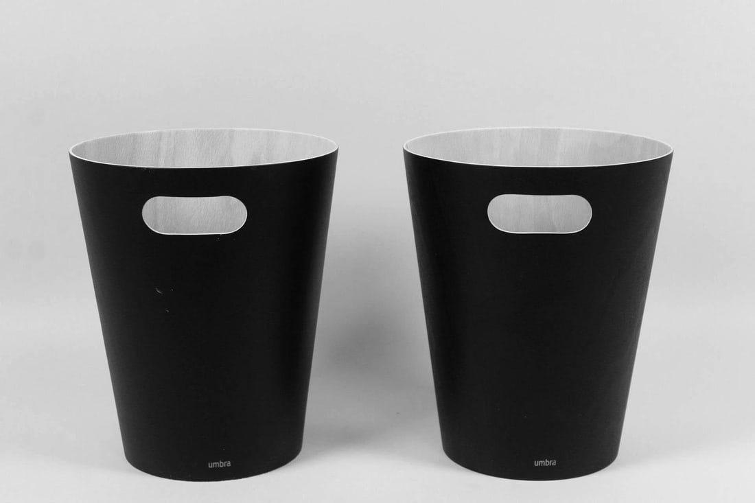 Pair of 'Woodrow' Bentwood Waste Baskets, Henry Huang for Umbra: Pair of 'Woodrow' Curved Wood Waste Baskets, Henry Huang for Umbra. These two trash can bins have tapered funnel bodies and open handles on one side, with a black finish on the exterior of the rounded