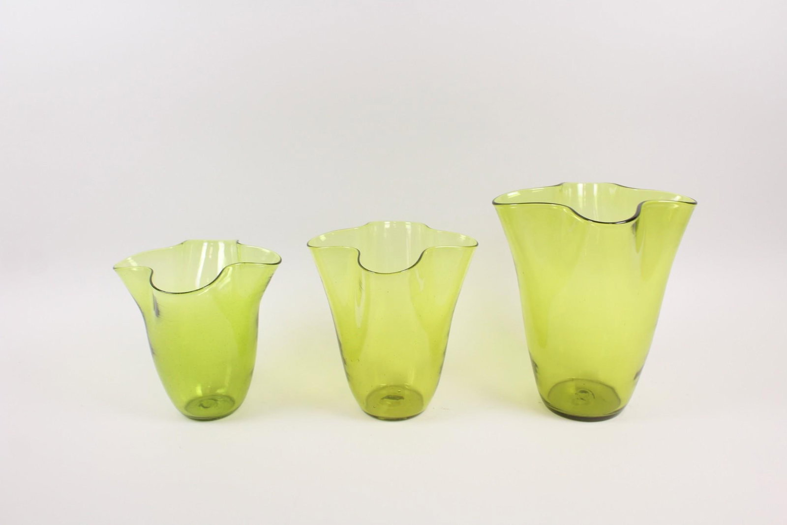 Set of 3 Italian Green Glass Handkerchief Vase: Set of 3 Italian Green Glass Handkerchief Vase. There are no apparent markings. Small medium and large. Dimensions are 11.5 in h x 10 in w x 10 in d. The two smaller are 8.5 & 9.5 in h x 9 in x 9 in. 