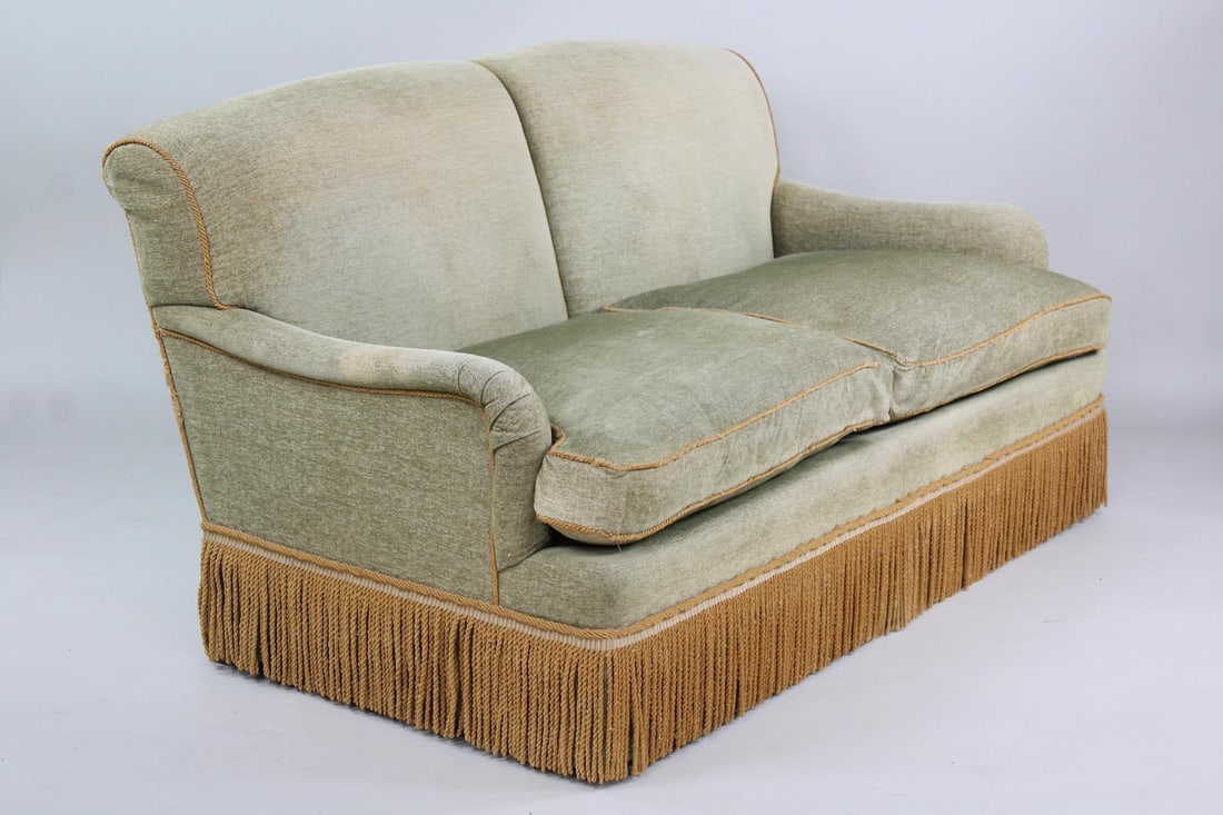 Green & Gold Tassel Fringe Sofa: Green & Gold Tassel Fringe Sofa. This down stuffed cushion 2-seat sofa is upholstered in a green fabric with twisted gold colored rope trim and long fringe skirt along the bottom hem concealing the fe