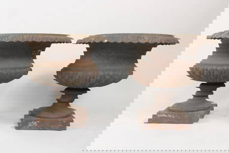 Pair of Cast Iron Urn Planters on Pedestal: Pair of Cast Iron Urn Planters on Pedestal. Great wide iron planters with scalloped edge, nice patina to the surface. Dimensions are 17.5 in h x 19.5 in w x 19.5 in d. Condition is good overall.
