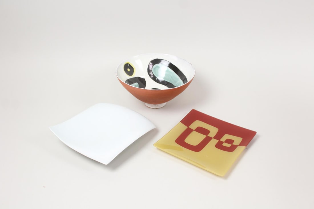 Lot of 3 Mid-Century Modern Glass & Ceramics: Lot of 3 Mid-Century Modern Glass & Ceramics. Includes a white ceramic freeform square dish, a red & yellow glass dish with a TOKYObay label on the back, and a redware bowl with a painted abstract des