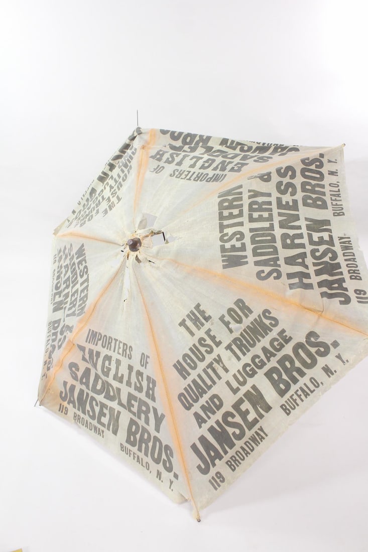 Western Saddles and Trunks Advertising Canvas Umbrella, Buffalo, NY: Western Saddles and Trunks Advertising Canvas Umbrella, Buffalo, NY. This canvas umbrella has a wooden pole, missing the lower half section of the pole. Dimensions are 50 in h x 52 in w x 52 in d. Con