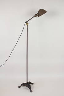 Industrial Floor Lamp with Claw Foot Cast Iron Base: Industrial Floor Lamp with Ornate Cast Iron Base. Metal floor lamp with adjustable height and shade angle, marked Hubbell on the shade. Three legged ornate base is cast iron. Dimensions are 49 to 72 i