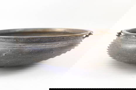 Large Bronze Indian Urli Vessel Bowl: Large Bronze Indian Urli Vessel Bowl. This large flat bowl has handles on each side. Very heavy bronze with great patina. Dimensions are 7.5 in h x 25.5 in w x 22.75 in d. Condition is good. Please ca