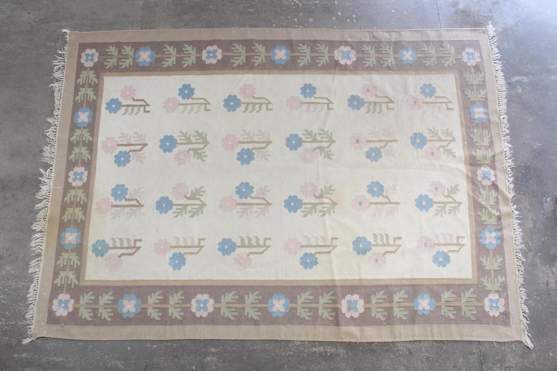 Dhurrie Rug with Pink & Blue Flowers, 9x6 Ft: 9x6 Ft Dhurrie Rug with Pink & Blue Flowers. Wool flat weave rug with an off-white ground, with a brown border and center filled with pink and blue flowers. Dimensions are 111 in h x 75 in w x .25 in