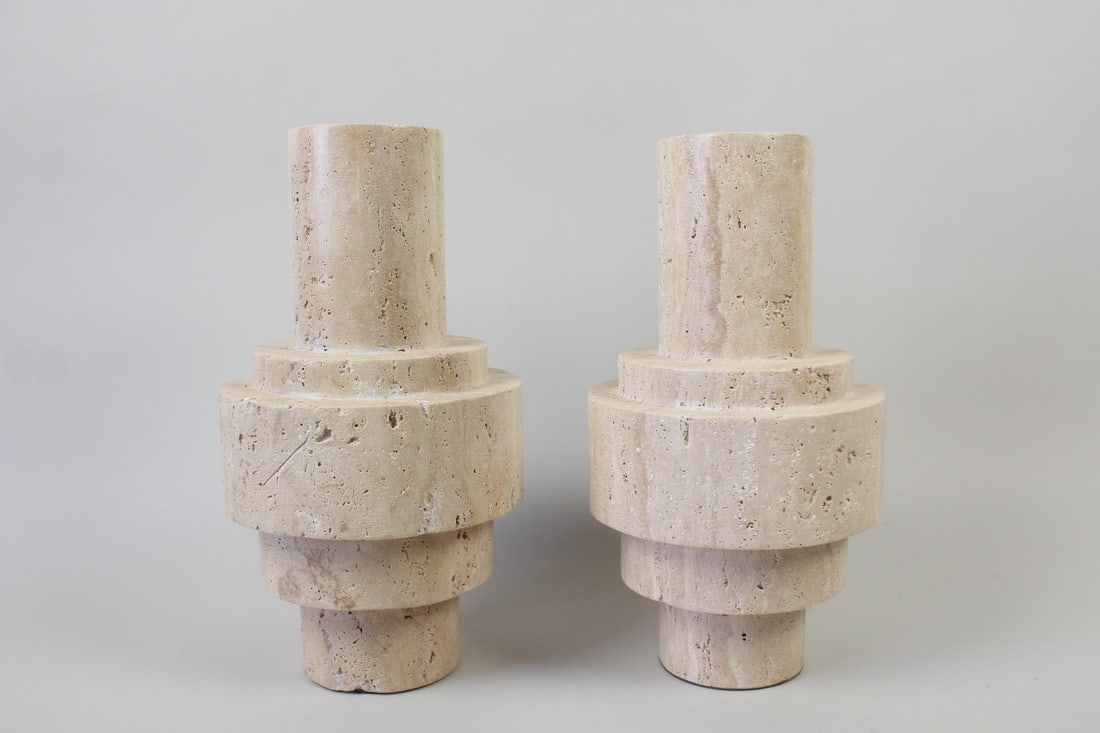 Pair of Dome Deco Travertine "Etna" Vases: Pair of Dome Deco Travertine "Etna" Vases. Matching pair of cylindrical vases or centerpieces in 2 slightly different heights. Marked Dome Deco. Dimensions are 14.75 in h x 7.25 in w x 7.25 in d. Cond