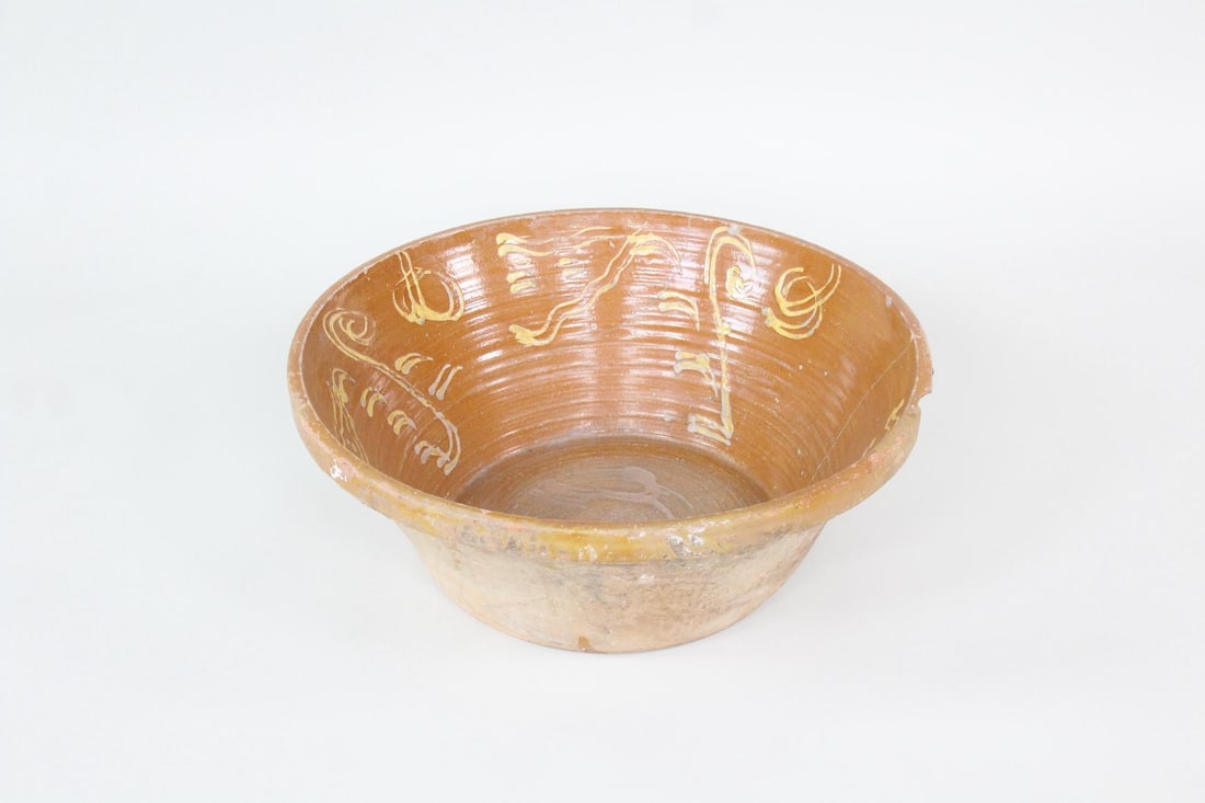 Large Slip Decorated Redware Dough Bowl: Large Slip Decorated Redware Bowl. Very large 26 in diameter redware vessel with trailed slip decoration on the interior. Dimensions are 9.5 in h x 26 in w x 26 in d. Condition is fair with cracks and