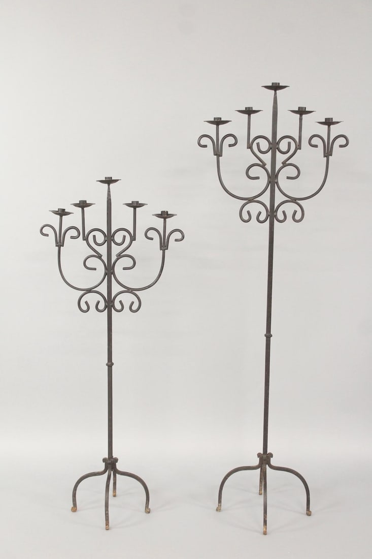 Pair of Floor Standing Wrought Iron Candelabras: Pair of Gothic Revival Floor Standing Wrought Iron Candelabras. Matching pair of 5 arm candelabras with black finish, in 2 heights. Dimensions are 48 in h x 19.5 in w x 11.5 in d and 60 in h x 20 in w
