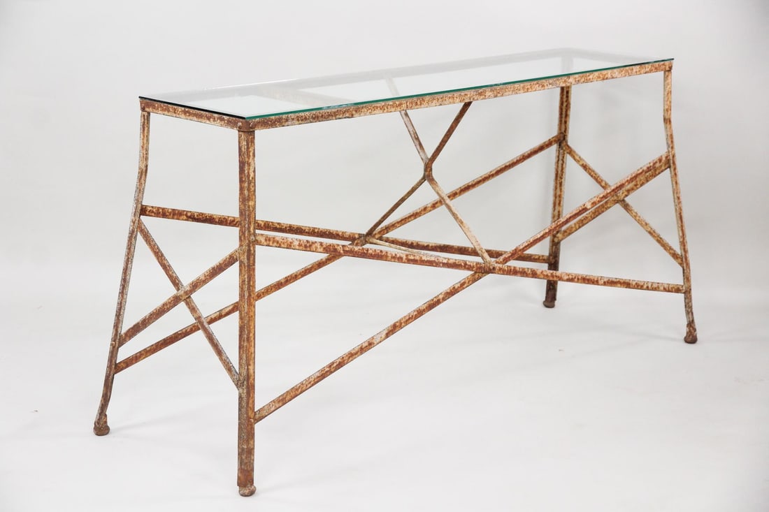 Industrial Iron & Glass Console Table: Industrial Iron & Glass Console Table. Unusual table has a frame of iron straps with splayed legs and glass top. Dimensions are 32.25 in h x 67 in w x 22 in d. Condition is good with surface rust to b