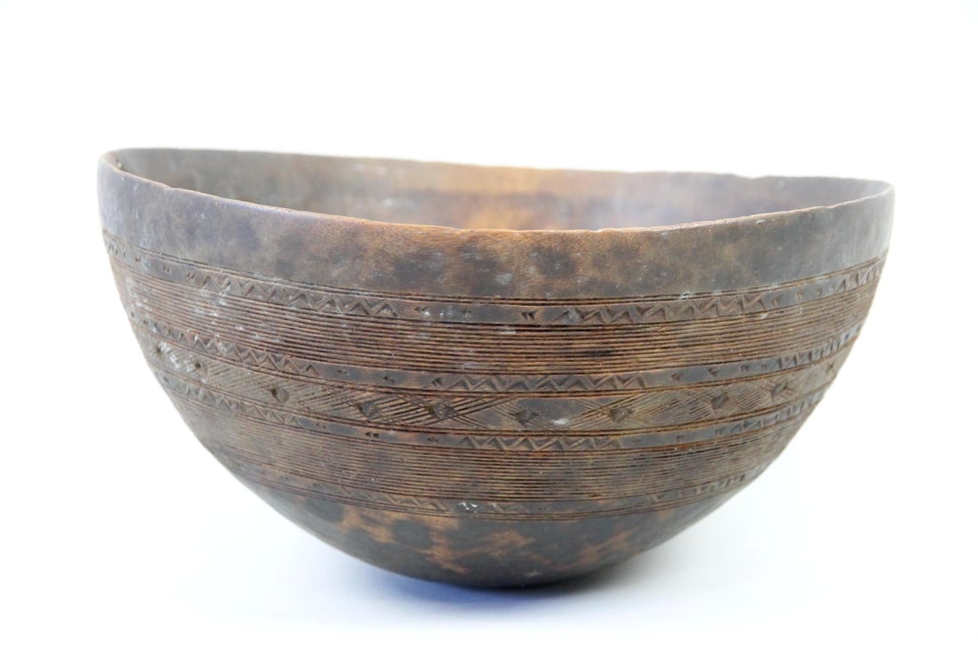 Hand Carved Tuareg Wooden Milk Bowl: African Tuareg Wooden Milk Bowl, Geometric Pattern. A deep wooden bowl with intricate, traditional geometric designs incised on around the exterior. It has a rich patina and an attractive repair with 