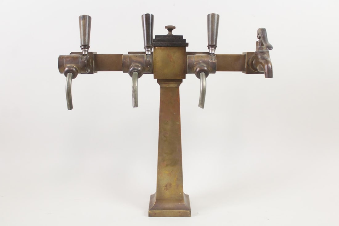 Brass T-Bar Draft Beer Tap Tower: Art Deco Brass T-Bar Draft Beer Tap Tower. Made of brass with a wooden lid in the center, handsome tap tower has 3 taps and a faucet. Dimensions are 18 in h x 18 in w x 8.25 in d. Condition is good wi