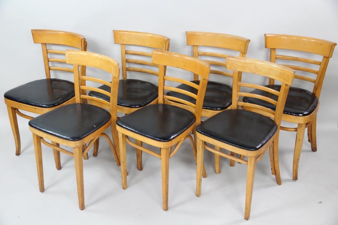 Set of 7 Astra Bentwood Cafe Bistro Chairs: Set of 7 Astra Bentwood Cafe Bistro Chairs. Matching set of bentwood chairs with ladder backs and shiny black vinyl seats, marked Astra Bentwood Furniture Co. Three are slightly smaller than the other