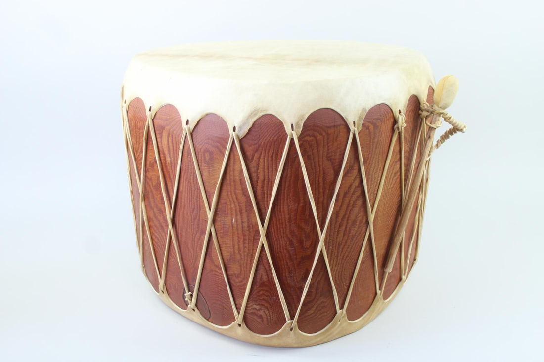 Large Ceremonial Rawhide & Wood Drum: Large Ceremonial Rawhide Drum. A beautifully hand crafted instrument with figured tree trunk and stretched animal hide. The drum beater has a carved wooden handle. Dimensions are 18.5 in h x 25.5 in w