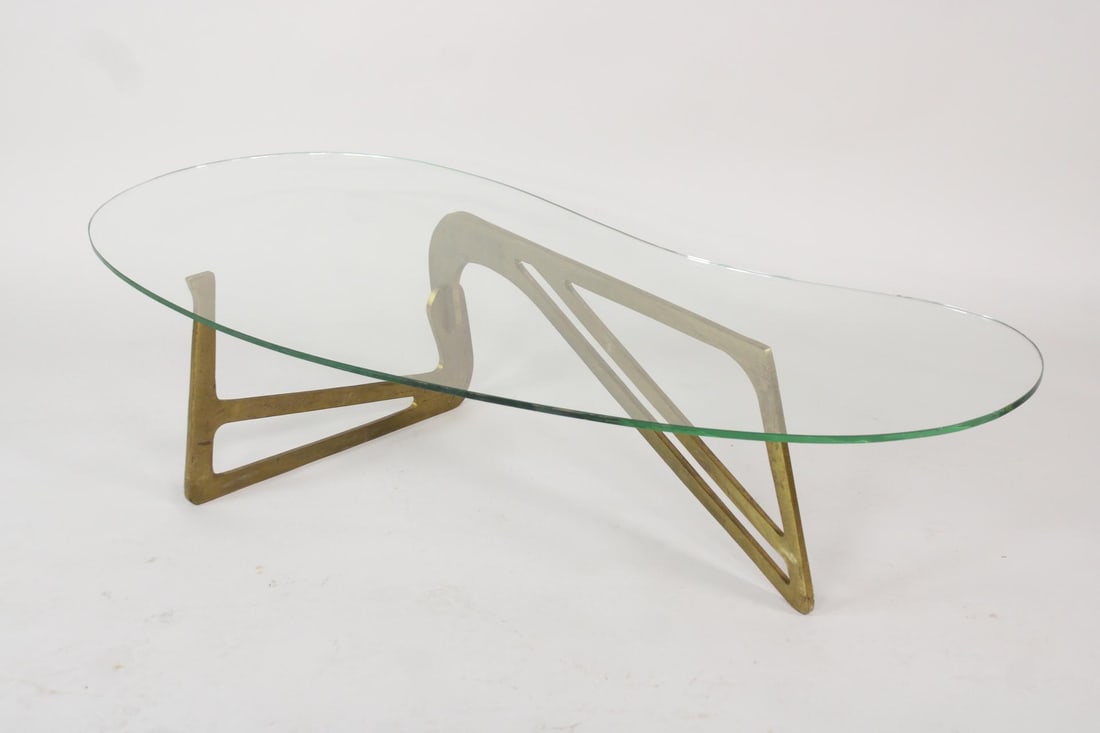 Sculptural Brass Glass Top Coffee Table, Manner of Noguchi: Sculptural Mid-Century Modern Brass Glass Top Coffee Table, Manner of Noguchi. Base is made of brass and comes apart into 2 pieces, with the clear glass top biomorphic in shape. Dimensions are 14 in h