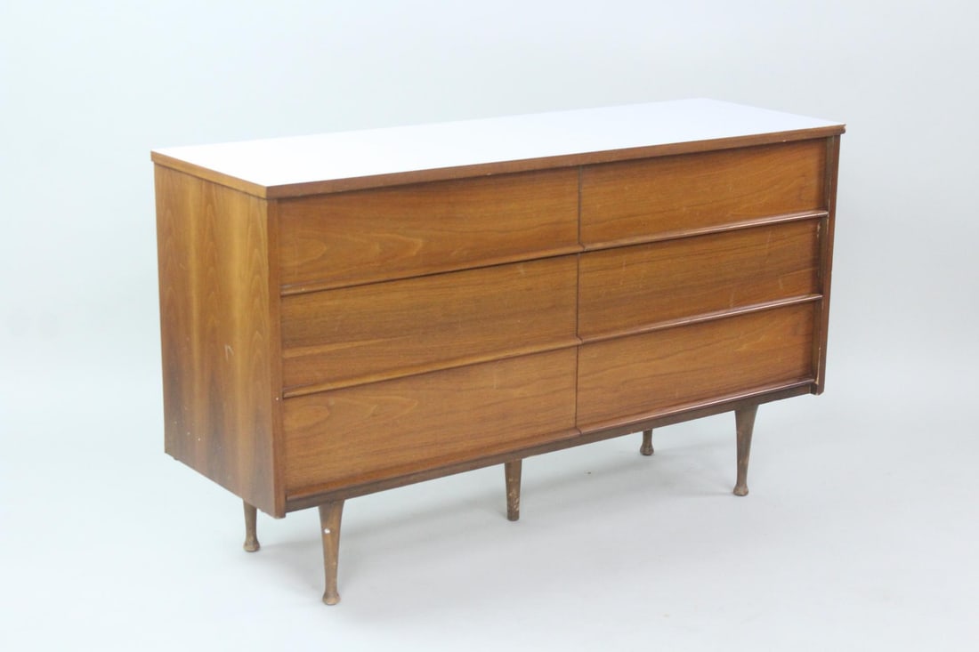 Mid-Century Modern Dresser with White Laminate Top: Mid-Century Modern Dresser with White Laminate Top. Six drawer wooden dresser with turned feet and white laminate top. Dimensions are 31.25 in h x 52 in w x 17 in d. Condition is good with minor scrat