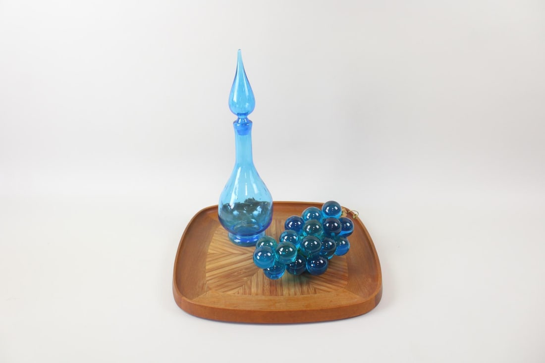Lot of 3 Mid-Century Decor, Dansk Tray, Glass Decanter, Grapes Sculpture: Lot of 3 Decor Items, Jens H. Quistgaard for Dansk Teak Tray & Others. Lot includes; a Dansk "Two Woods" teak & wood serving tray, a turquoise glass decanter with decorative topper, and a cluster of g