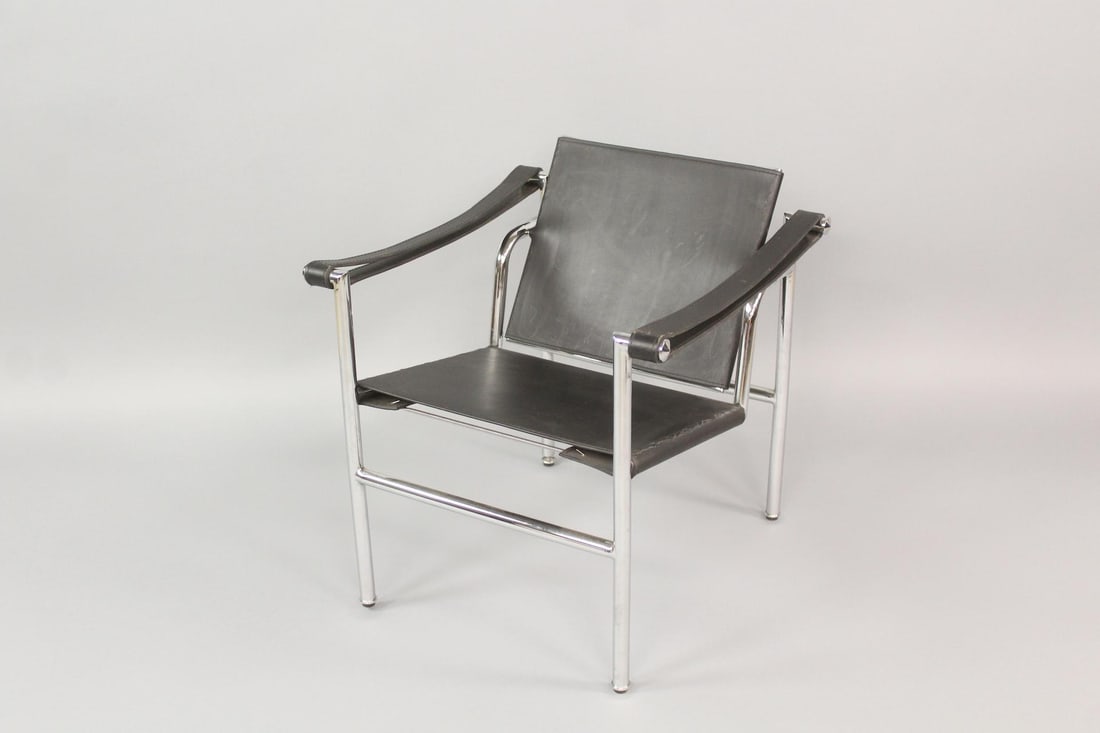 LC1 Black Leather & Chrome Sling Lounge Chair, Le Corbusier: LC1 Black Leather Lounge Chair, Le Corbusier. A classic chair with chrome frame, strap arms and black leather seat. Designed by Le Corbusier, with no marks. Dimensions are 25 in h x 24 in w x 24 in d.