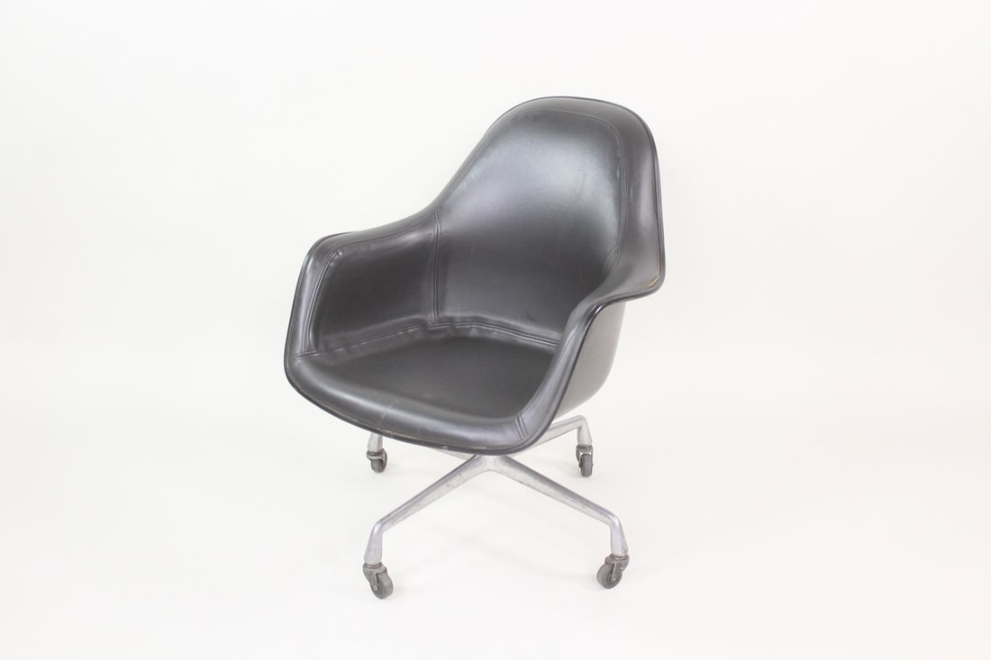 Eames for Herman Miller Padded Fiberglass Swivel Office Chair: Mid-Century Modern Herman Miller Fiberglass Office Chair. Iconic chair with molded fiberglass shell, four-star metal base with casters, and black vinyl or naugahyde padding. Herman Miller labels affix