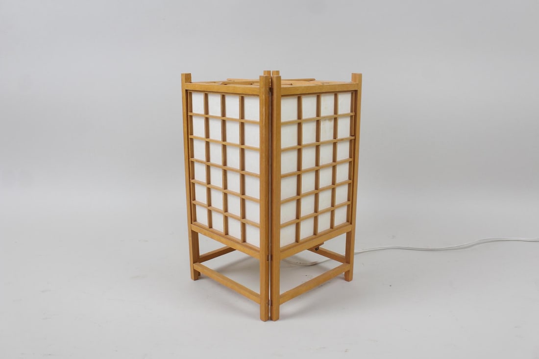 Mid-Century Modern Japanese Shoji Style Lamp: Mid Century Modern Japanese Shoji Style Lamp. Tabletop lamp has a wooden frame with windowpane style grid to the four faces of the paper covered shade. Dimensions are 11.5 in h x 7.5 in w x 7.5 in d.