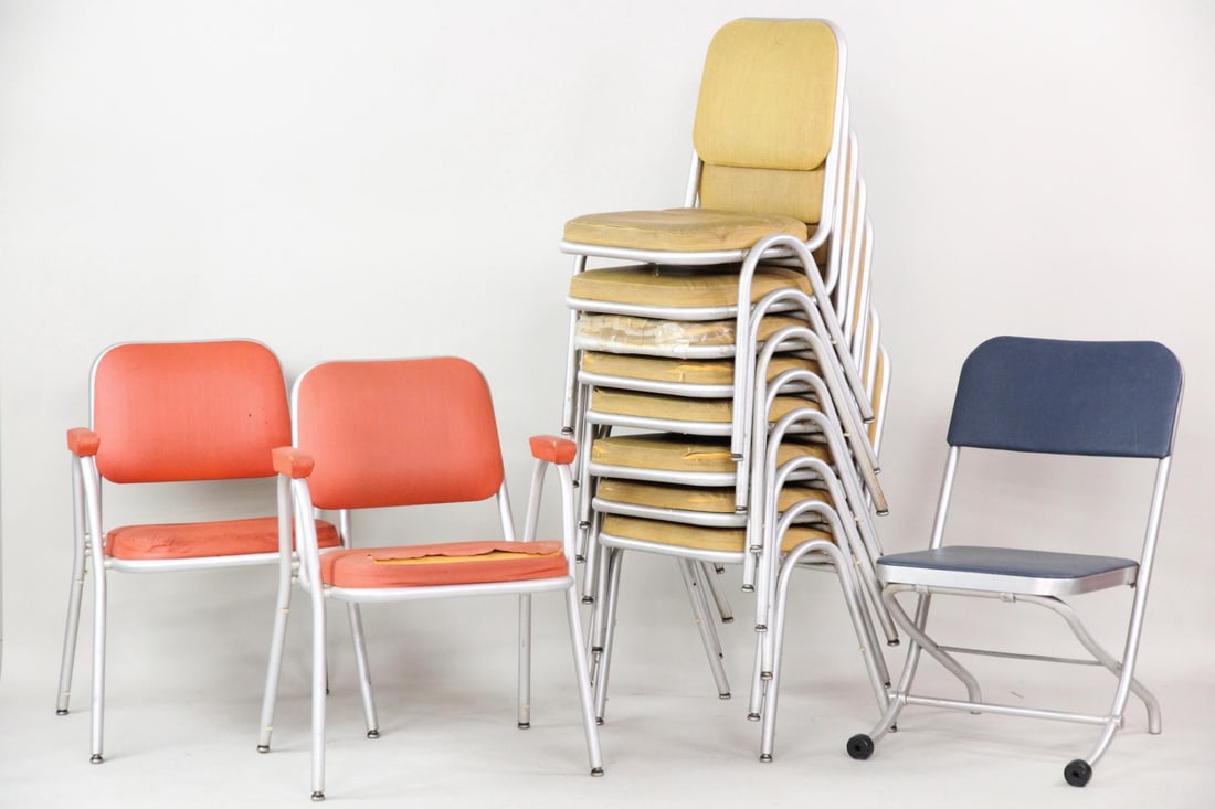 Lot of 11 Warren McArthur Aluminum Chairs: Lot of 11 Mid-Century Modern Warren McArthur Chairs in 3 Designs. Includes 8 stacking chairs with yellow upholstery, 2 armchairs with orange upholstery, and a single folding chair in navy. With Warren