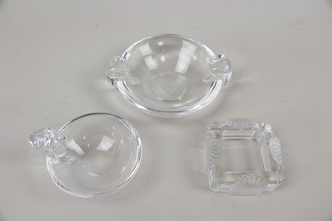 Lot of 3 Lalique & Steuben Glass Crystal Dishes, Ashtrays: Lot of 3 Lalique & Steuben Glass Crystal Dishes, Ashtrays. Two sculptural Steuben bowls, both with Steuben etched on underside. One square ashtray or dish with shell texture accents, Lalique etched si