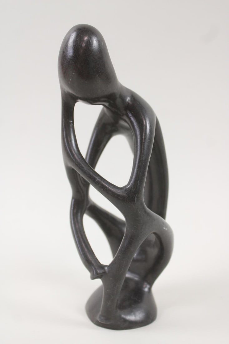 Modernist Abstract Soapstone Thinking Figure Sculpture: Modernist Abstract Soapstone Figurative Sculpture. A polished black soapstone sculpture with smooth curvilinear forms, suggestive of a familial embrace. Unsigned. Dimensions are 9.25 in h x 3 in w x 4