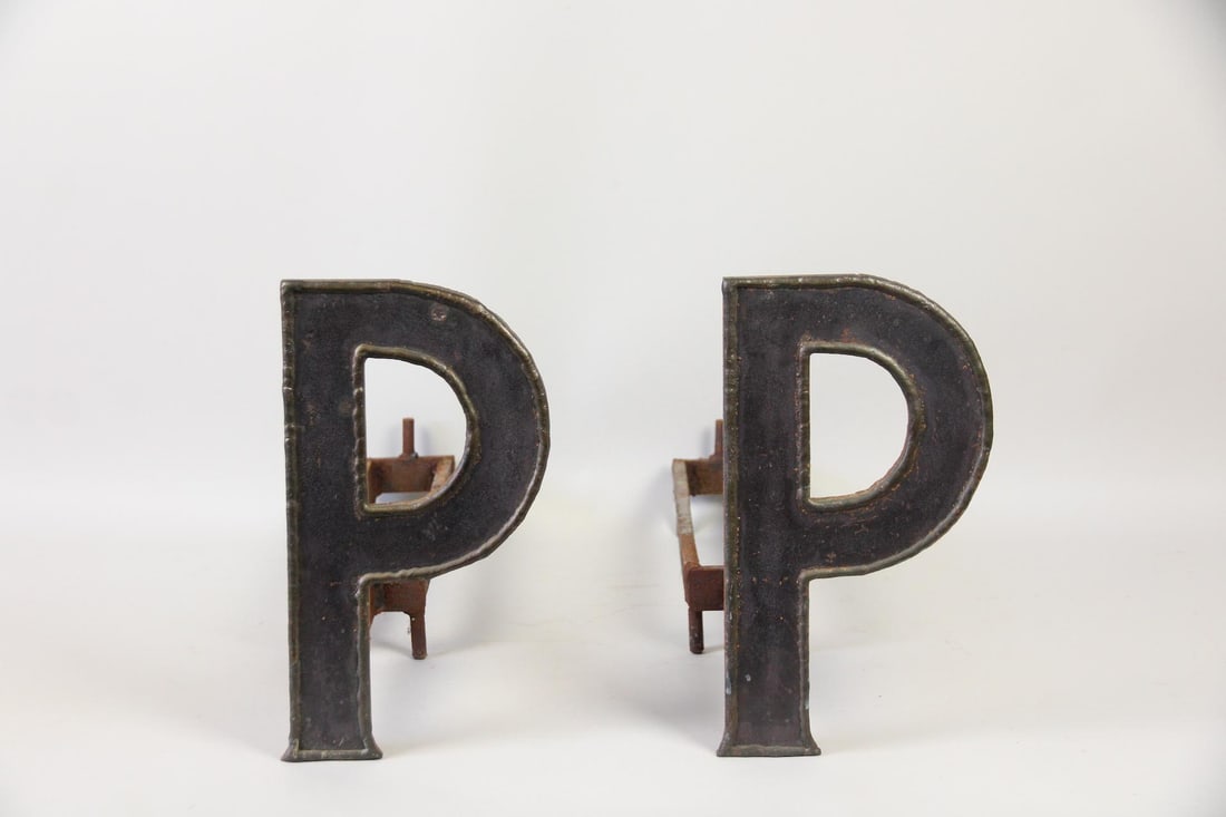 Pair of Cast Iron Letter "P" Andirons: Pair of Cast Iron Letter "P" Andirons. Matching pair of iron andirons, each with a capital letter "P." Dimensions are 14.5 in h x 8 in w x 25 in d. Condition is good with some rust and wear. Please ca