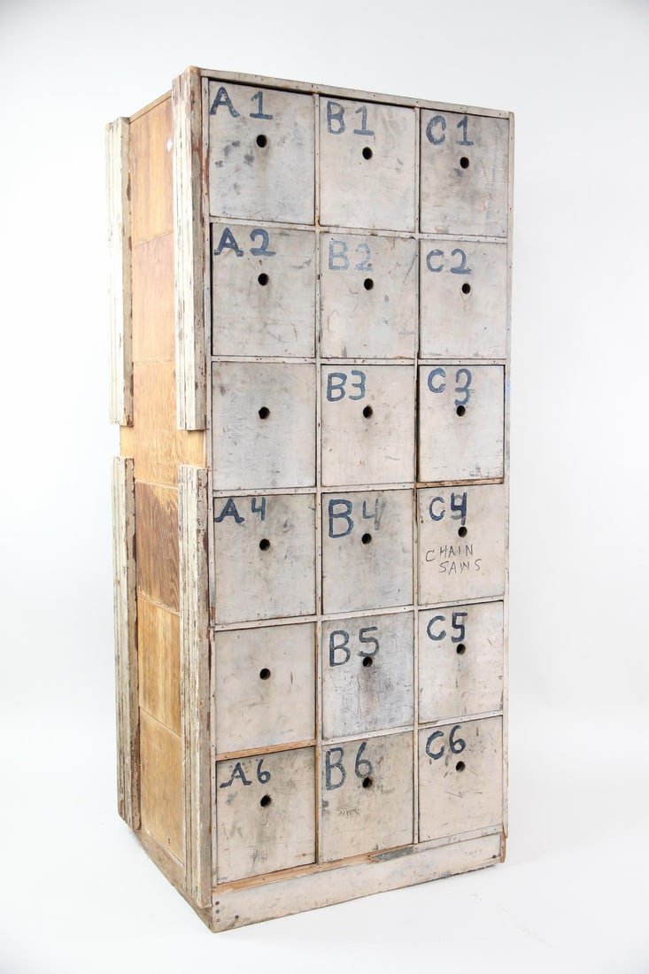 Minimalist Primitive Multi-Drawer Storage Cabinet: Prrimitive Industrial Hardware Store Multi-Drawer Storage Cabinet. Tall wooden cabinet with 18 drawers, painted gray. Drawers are labeled with hand written letters and numbers, with one labeled Chain