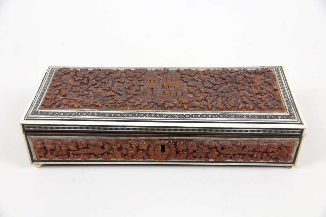 Anglo-Indian Carved Box with Sadeli Inlay: Anglo-Indian Carved Box with Sadeli Inlay. An elongated glove or storage box made from wood, likely teak or sandalwood. It features ornately carved floral, bird, and architectural motifs as well as