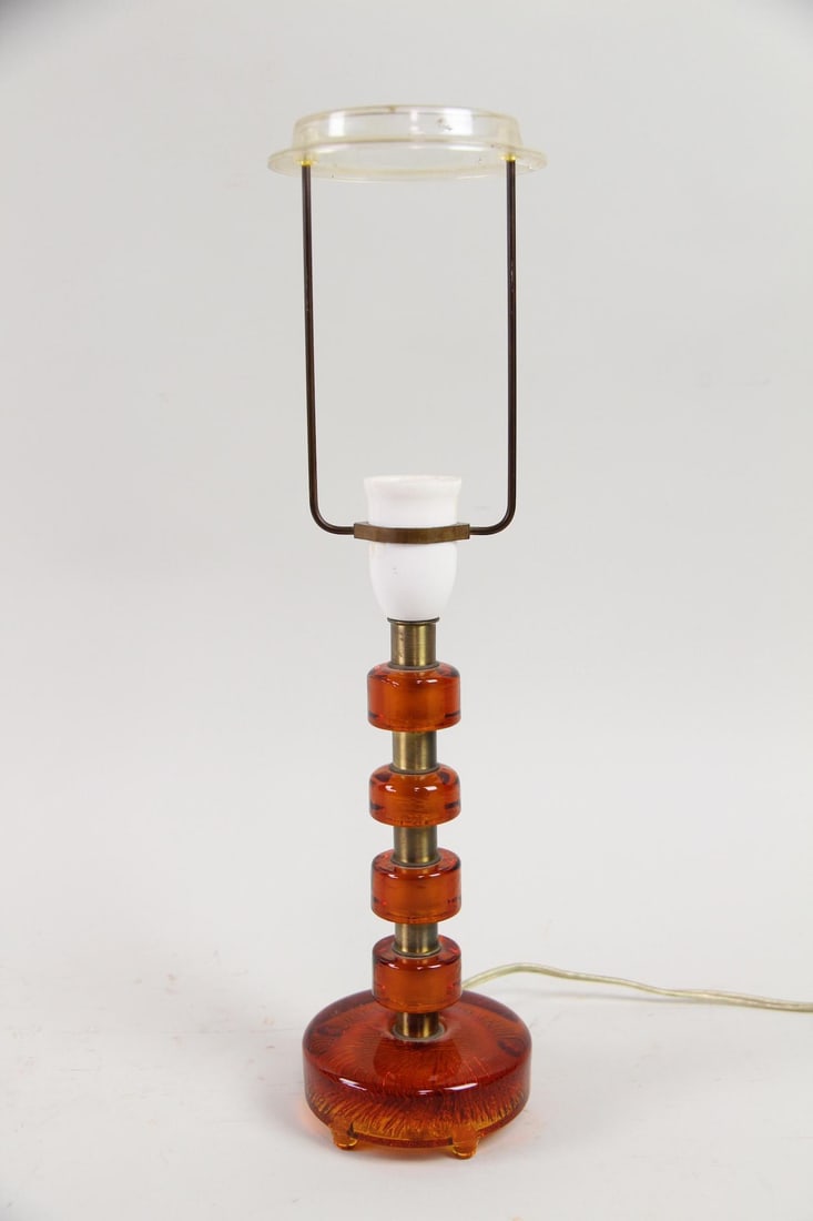 Carl Fagerlund Orrefors Amber Glass Lamp: Mid-Century Modern Carl Fagerlund for Orrefors Amber Glass & Brass Lamp. Table Lamp with amber glass and brass ring design. White fabric shade included. Dimensions of the lamp are 17 in h x 4 in w x
