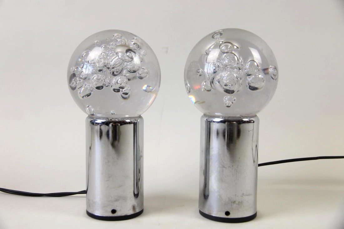 Pair of Space Age Lamps, Bubble Glass & Chrome: Pair of Space Age Lamps, Bubble Glass & Chrome. A pair of small lamps with bubble glass spheres and cylindrical chrome-plated bases. There is a switch that toggles between two colors of light. 