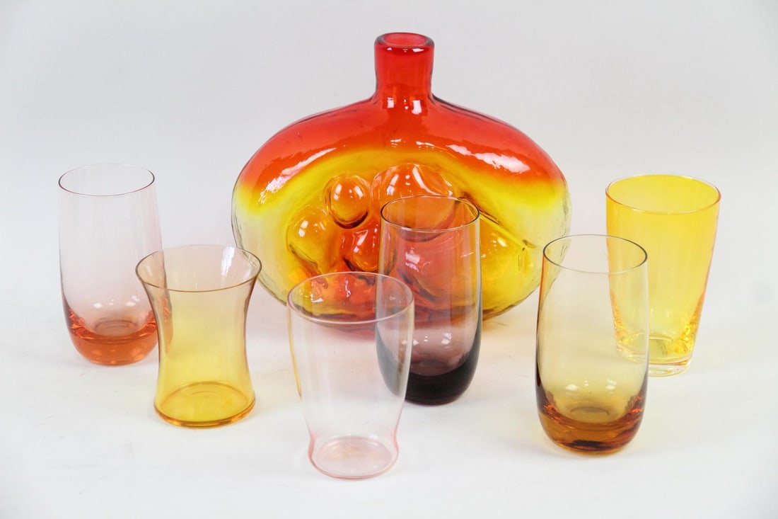 Lot of 7 Colorful Mid-Century Modern Glassware: Lot of 7 Colorful Mid-Century Modern Glassware. Includes a Blenko Wayne Husted "Mother & Child" Amberina decanter (missing stopper) and 6 drinking glasses in pink, purple and yellow. Dimensions are