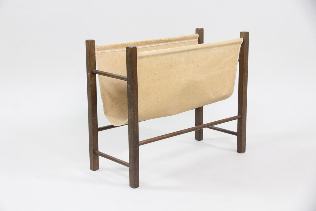 Danish Modern Canvas Sling Magazine Rack: Danish Mid-Century Modern Canvas Sling Magazine Rack. Minimalist magazine rack with wooden frame and canvas sling holder.Dimensions are 16 in h x 19.5 in w x 8.75 in d. Condition is good with some sta