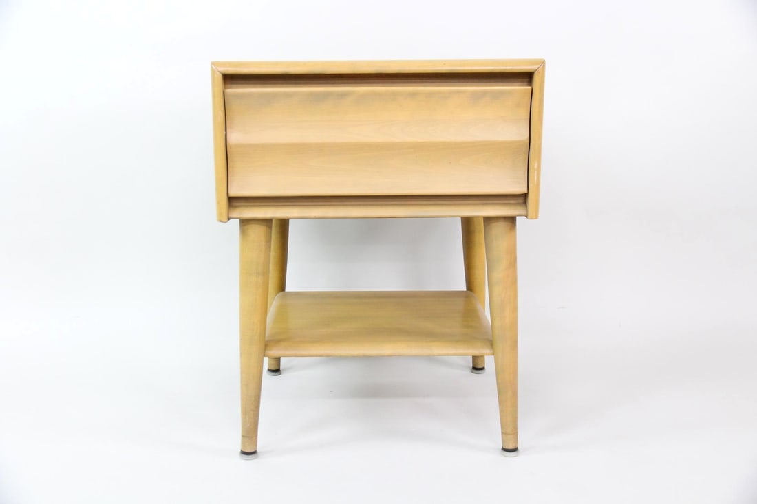 Heywood Wakefield 1-Drawer Side Table, Blonde Wood: Mid-Century Modern Heywood Wakefield Side Table Night Stand. A small table that has a single dovetailed drawer with sculptural drawer face, one open lower shelf, and tall tapered legs. Made of blonde
