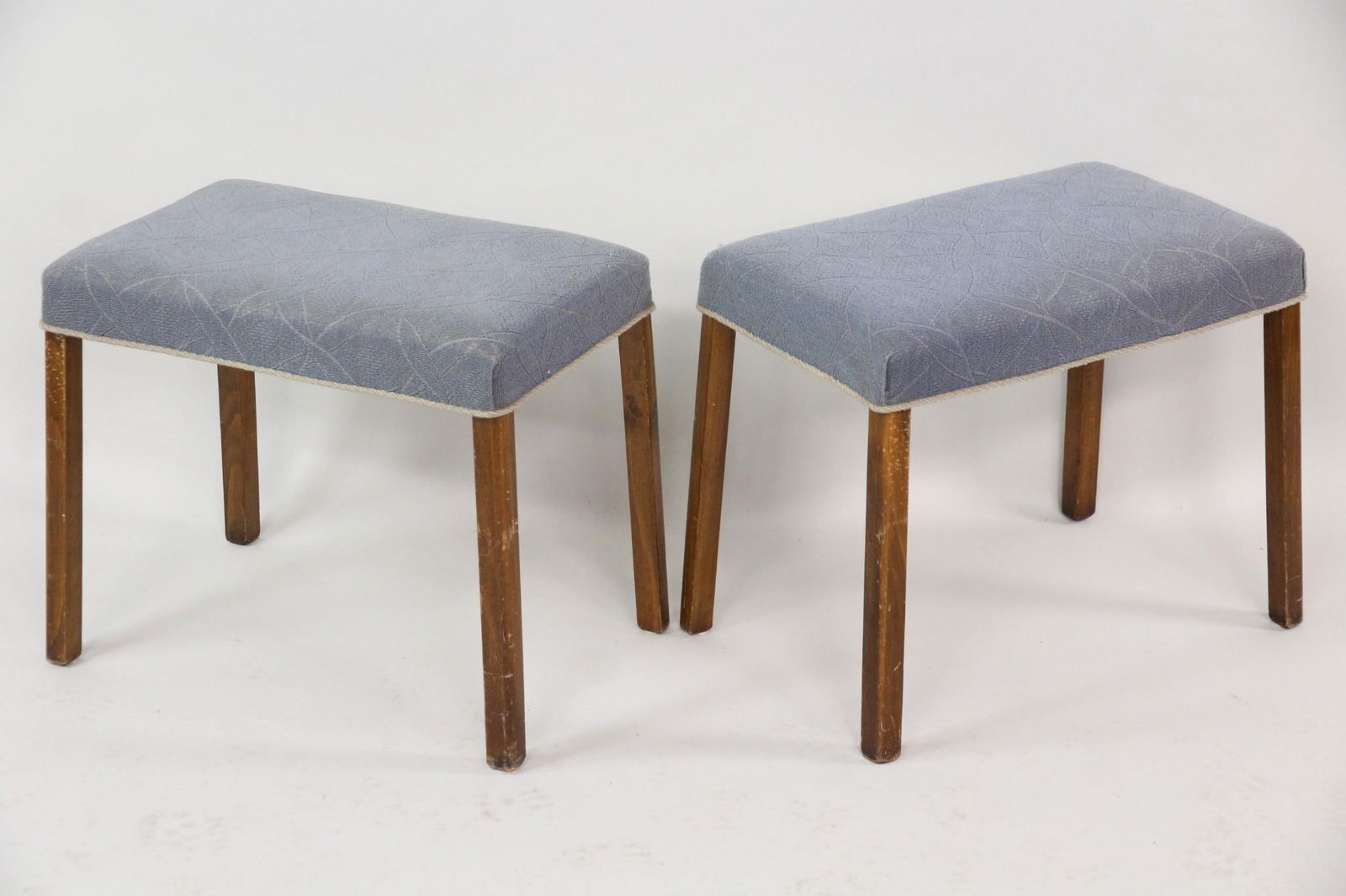 Pair of Danish Modern Footstools in Blue: Pair of Danish Mid-Century Modern Foot Stools, Ottomans. Great matching pair of stools with wooden frames and textured blue fabric seats, edged with piping.Dimensions are 16 in h x 19 in w x 12 in d.
