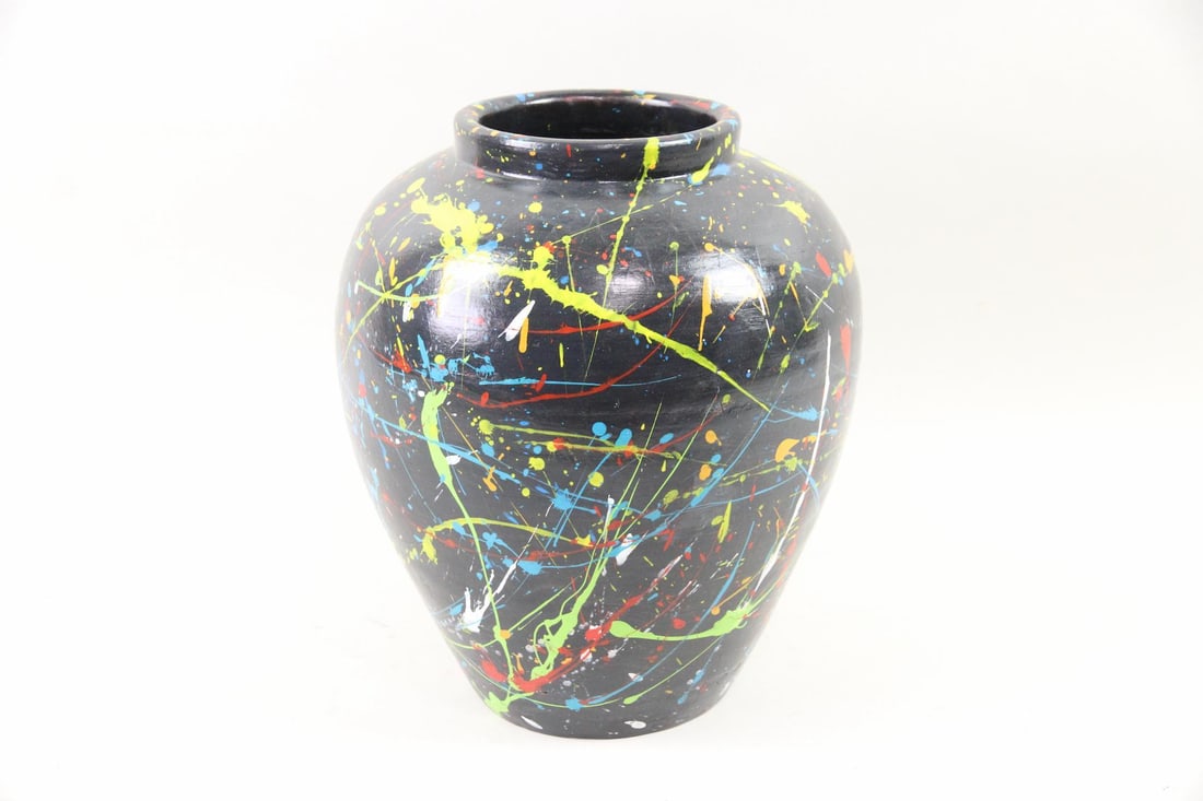 Ceramic Vase with Abstract Splatter Paint: Ceramic Vase with Abstract Splatter Paint. This large vase has a black surface with colorful abstract paint splatters and drips. Dimensions are 14 in h x 11.5 in w x 11.5 in d. Condition is good