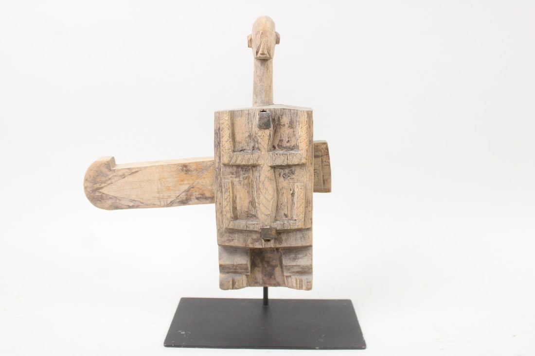 African Dogon Figural Door Slip Lock: Carved Wood Dogon Figural Door Slip Lock. Carved wood lock in the shape of a human figure, with a carved lizard on the front. From the Mali village of Dianveli Madnoe. Mounted on a black metal stand.