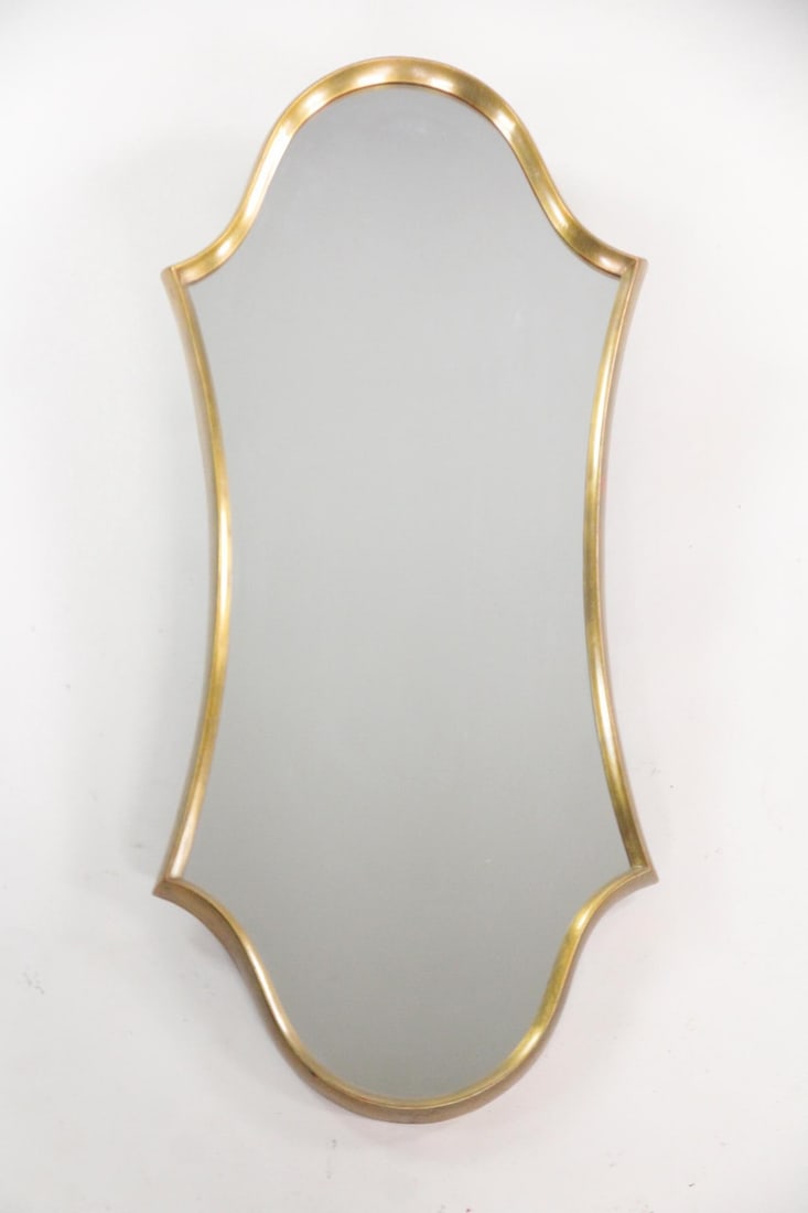 Hollywood Regency Giltwood Hourglass Mirror: Hollywood Regency Mid-Century Modern Giltwood Hourglass Mirror. Wall mirror with hourglass shaped giltwood frame. Dimensions are 47.25 in h x 22 in w x 2 in d. Condition is good with minor spots of